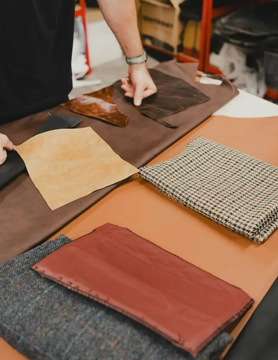 革や布のサンプルを並べて色を見比べている作業台